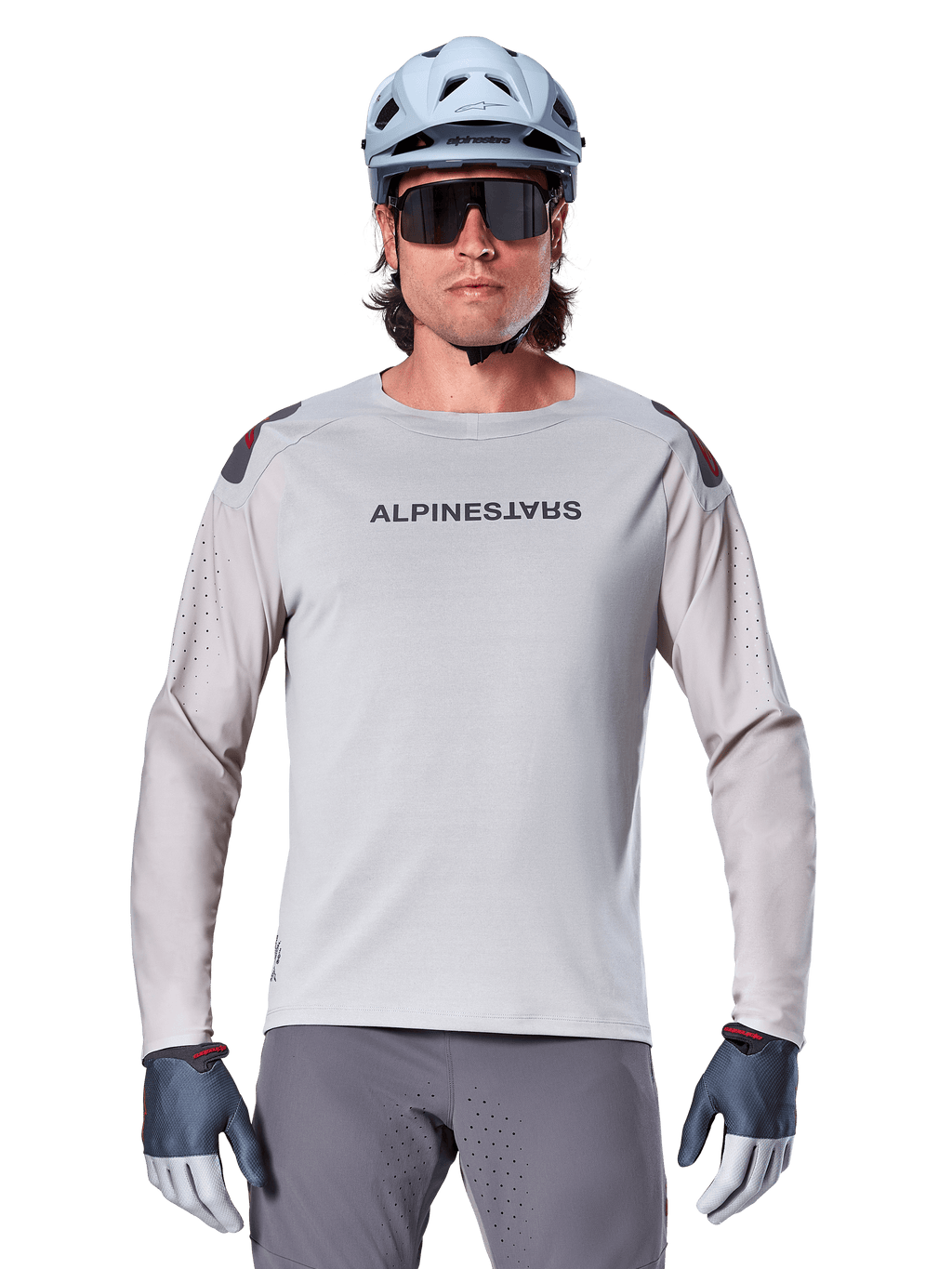 Alpinestars A-Aria Polartec Switch Long Sleeve Jersey, Light Gray mountain bike jersey featuring laser perforations on sleeves and chest branding, worn with light blue helmet, sunglasses, and gray gloves