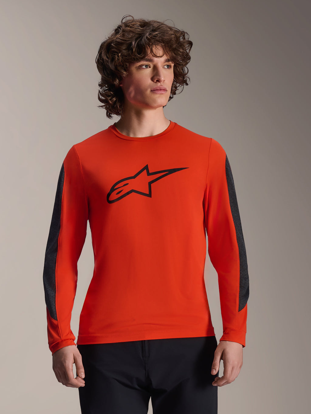 Maillot à manches longues Alpinestars A-Dura Insert Astar, orange avec logo Astar noir, empiècements de manches gris foncé résistants, porté par un mannequin homme, vêtement de cyclisme VTT haute performance