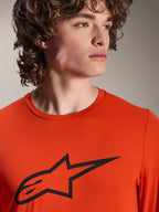 Maillot Alpinestars A-Dura Insert Astar, maillot de VTT à manches longues, Spicy Orange, avec logo Alpinestars Astar noir sur la poitrine, vue rapprochée sur un modèle masculin