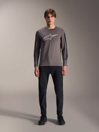 Maillot Alpinestars A-Dura Insert Astar, maillot de VTT à manches longues, gris foncé, arborant un logo Astar gris clair distinctif sur la poitrine et des empiècements texturés plus sombres sur les manches, porté par un mannequin avec pantalon et chaussures noirs, équipement de performance pour le VTT