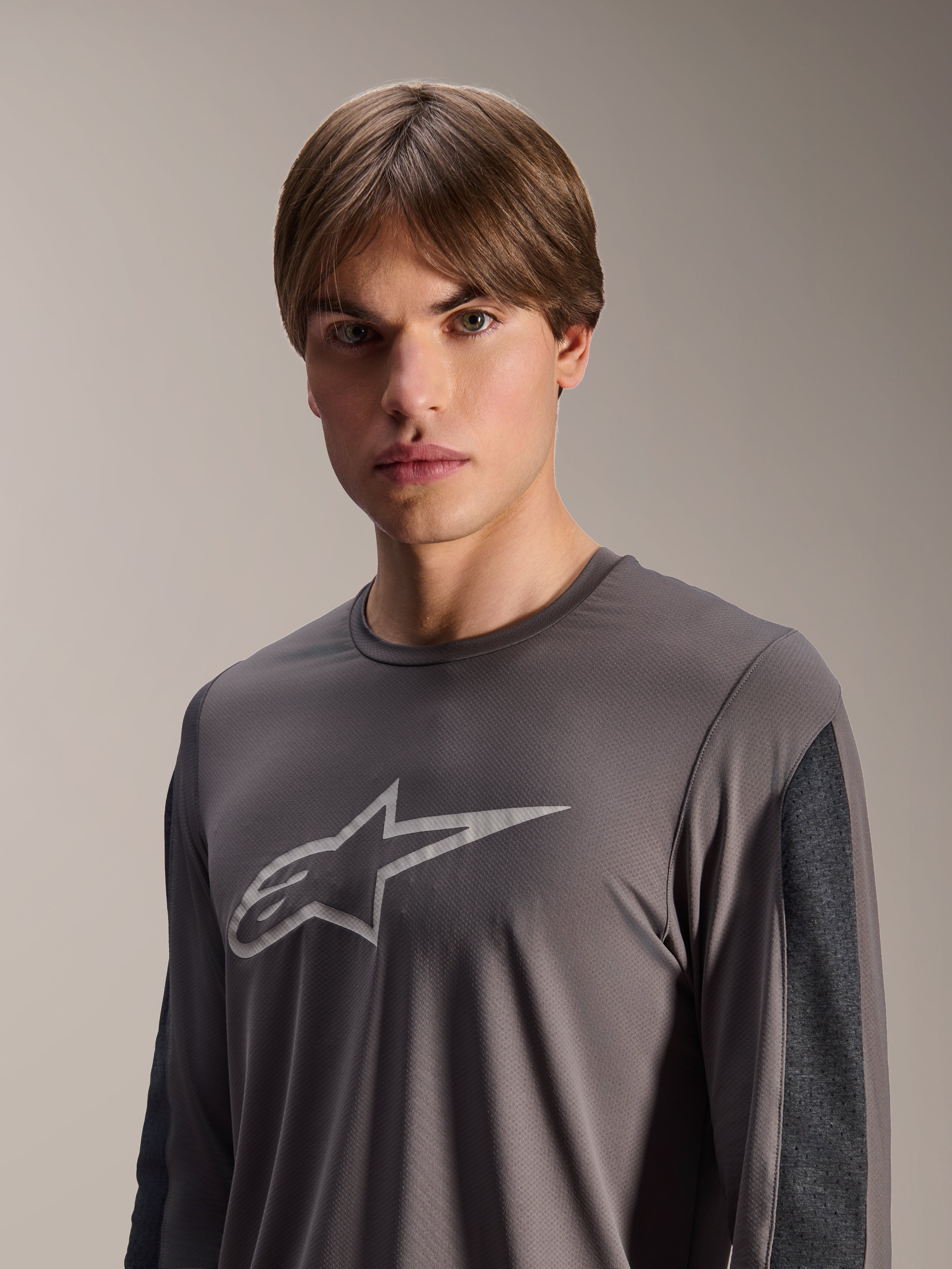 Maillot Alpinestars A-Dura Insert Astar, maillot de VTT à manches longues, gris foncé, avec un logo Astar gris clair sur la poitrine et des empiècements de manches gris foncé contrastés, vêtement de performance technique pour le cyclisme tout-terrain