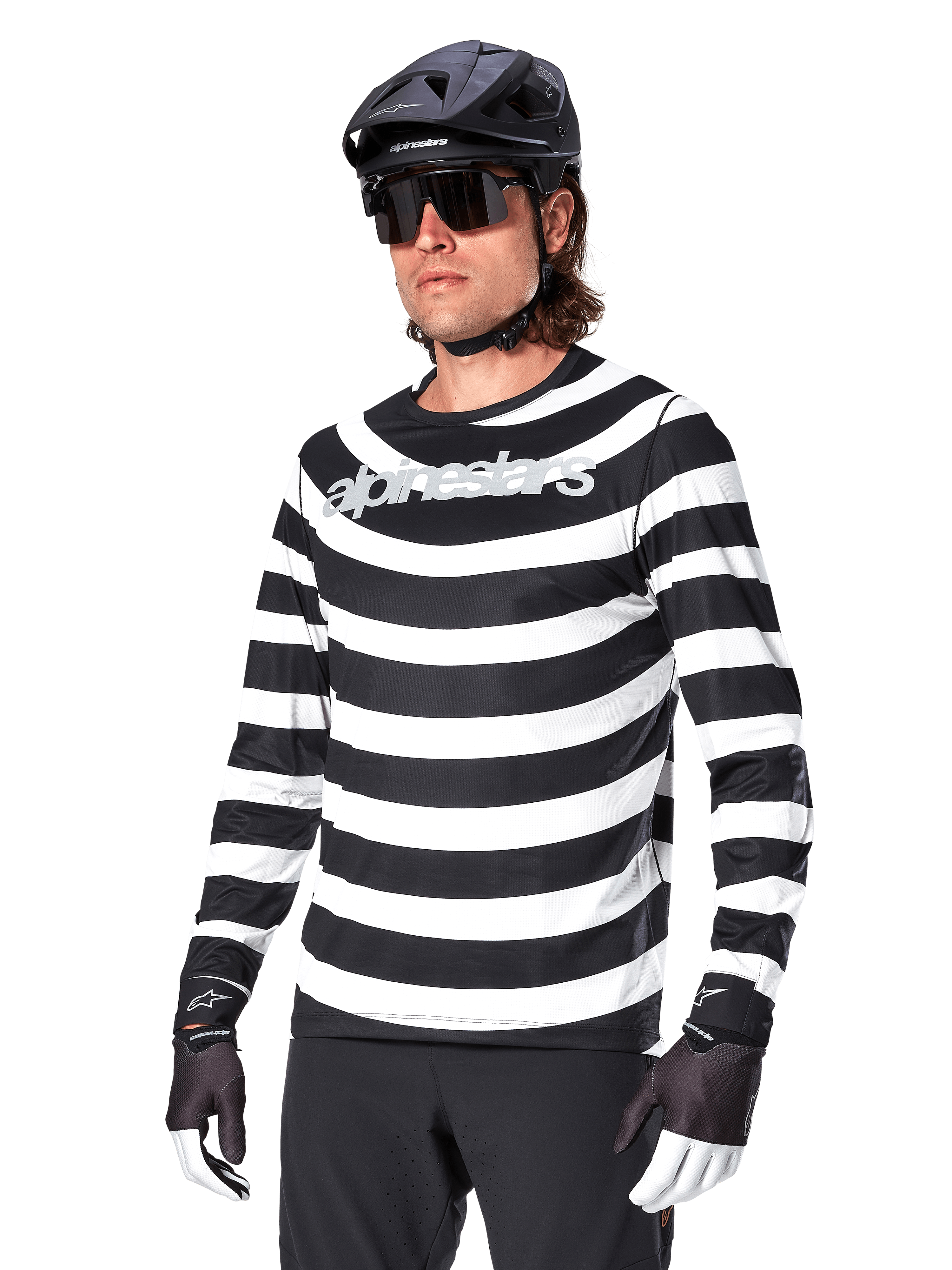 Alpinestars A-Aria Oscar Long Sleeve Jersey, MTB cycling jersey, Black and white horizontal stripes, worn with a black helmet and sunglasses, featuring Alpinestars branding on the chest, performance mountain bike apparel