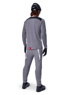 Alpinestars A-Dura Dri Astar Jersey - Long Sleeve, Dark Gray, back view of rider wearing matching pants and black helmet, features black shoulder panels and a small red tag at the hem, technical off-road cycling gear