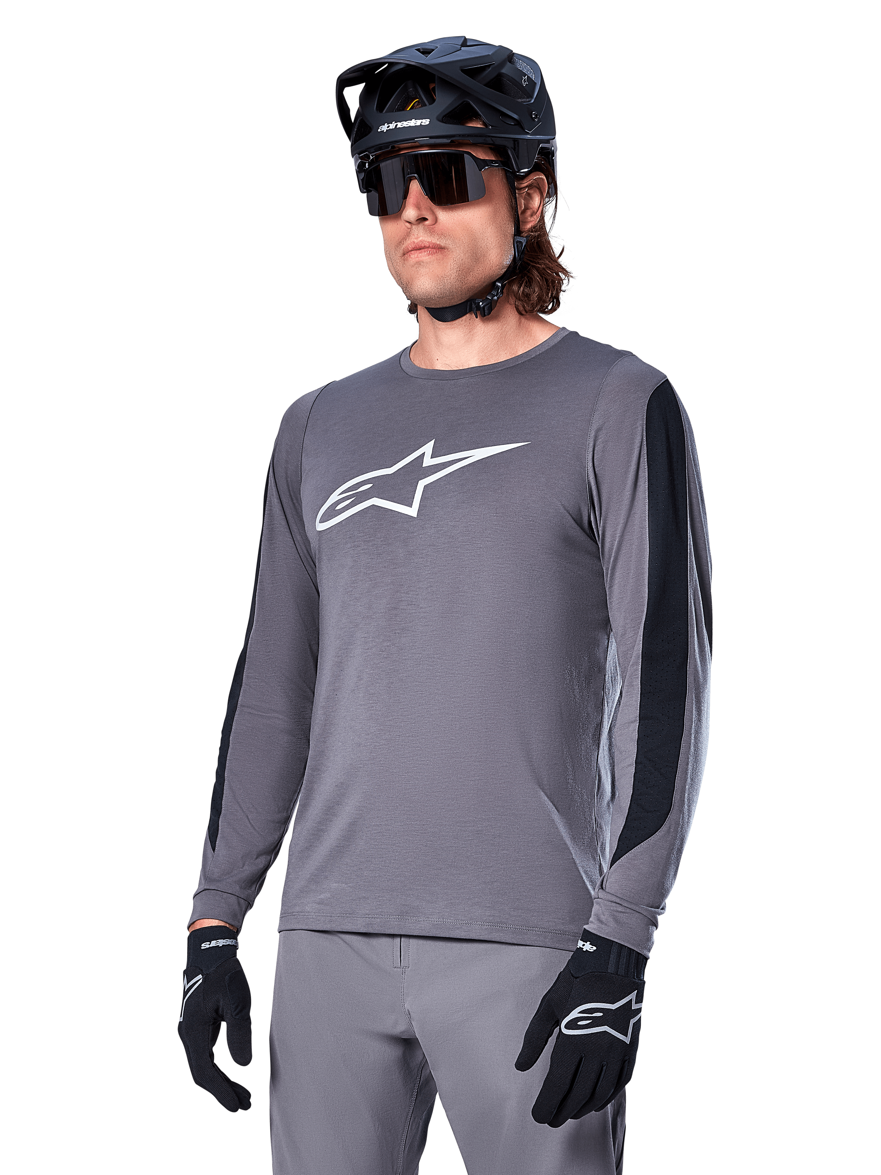 Alpinestars A-Dura Dri Astar Jersey Long Sleeve, Dark Gray with white chest logo and black mesh side panels, MTB mountain biking jersey, worn with black helmet, sunglasses, and matching gray pants