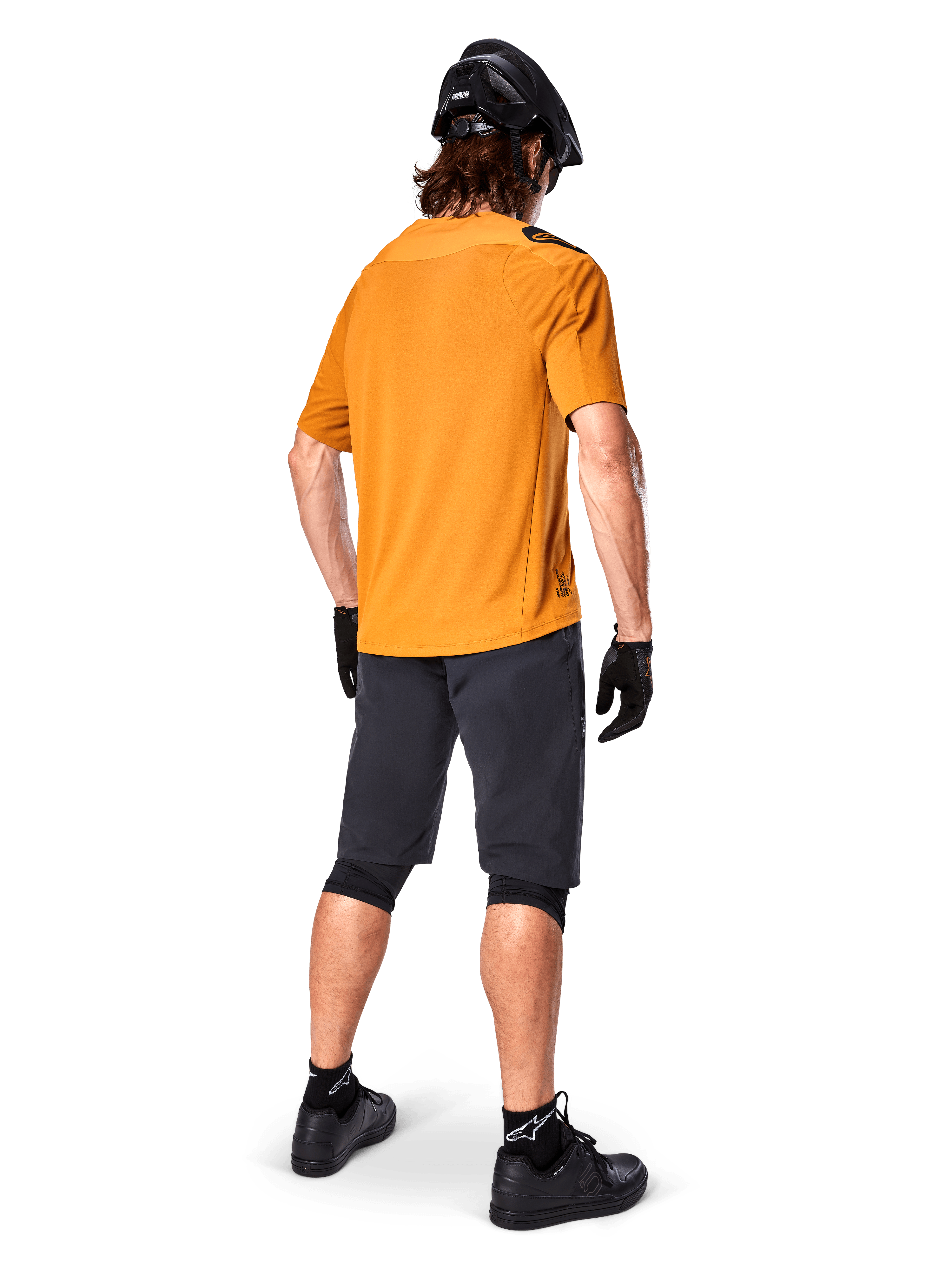 Alpinestars A-Aria Polartec Switch Jersey, Short Sleeve MTB Jersey, Dark Gold, rear view of model wearing dark gray mountain bike shorts, black helmet, and gloves, technical cycling apparel for off-road trails