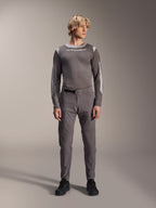 Alpinestars A-Dura Elite Pants, pantalon de VTT gris foncé, vue en pied, porté avec un maillot de performance gris assorti à manches longues orné du logo Alpinestars, chaussures noires avec accents rouges, tenue de cyclisme sportive