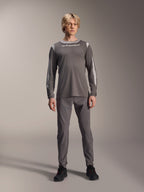 Maillot à manches longues Alpinestars A-Dura Dri Wool, gris foncé, porté par un mannequin avec un pantalon gris assorti et des chaussures noires, logo Alpinestars blanc sur la poitrine, panneaux en maille gris clair sur les épaules et les manches, équipement technique de VTT
