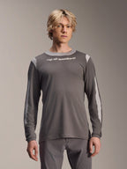 Maillot à manches longues Alpinestars A-Dura Dri Wool, gris foncé, porté par un mannequin homme, avec des panneaux en maille gris clair sur les épaules et les manches, logo textuel blanc sur la poitrine, équipement de performance pour VTT