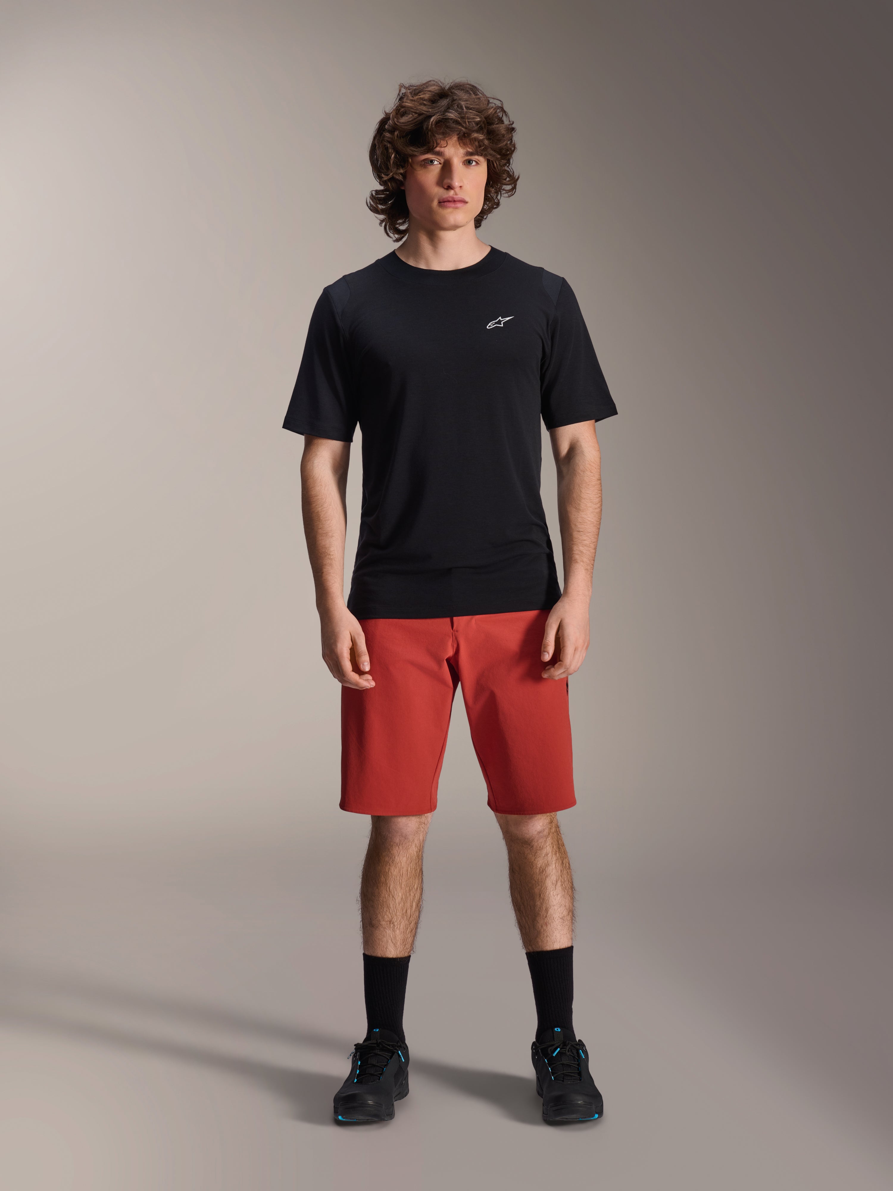 Alpinestars A-Dura Elite Shorts, short de VTT, orange foncé, porté avec un maillot noir à manches courtes et des chaussures de cyclisme, vêtement de cyclisme haute performance pour le VTT