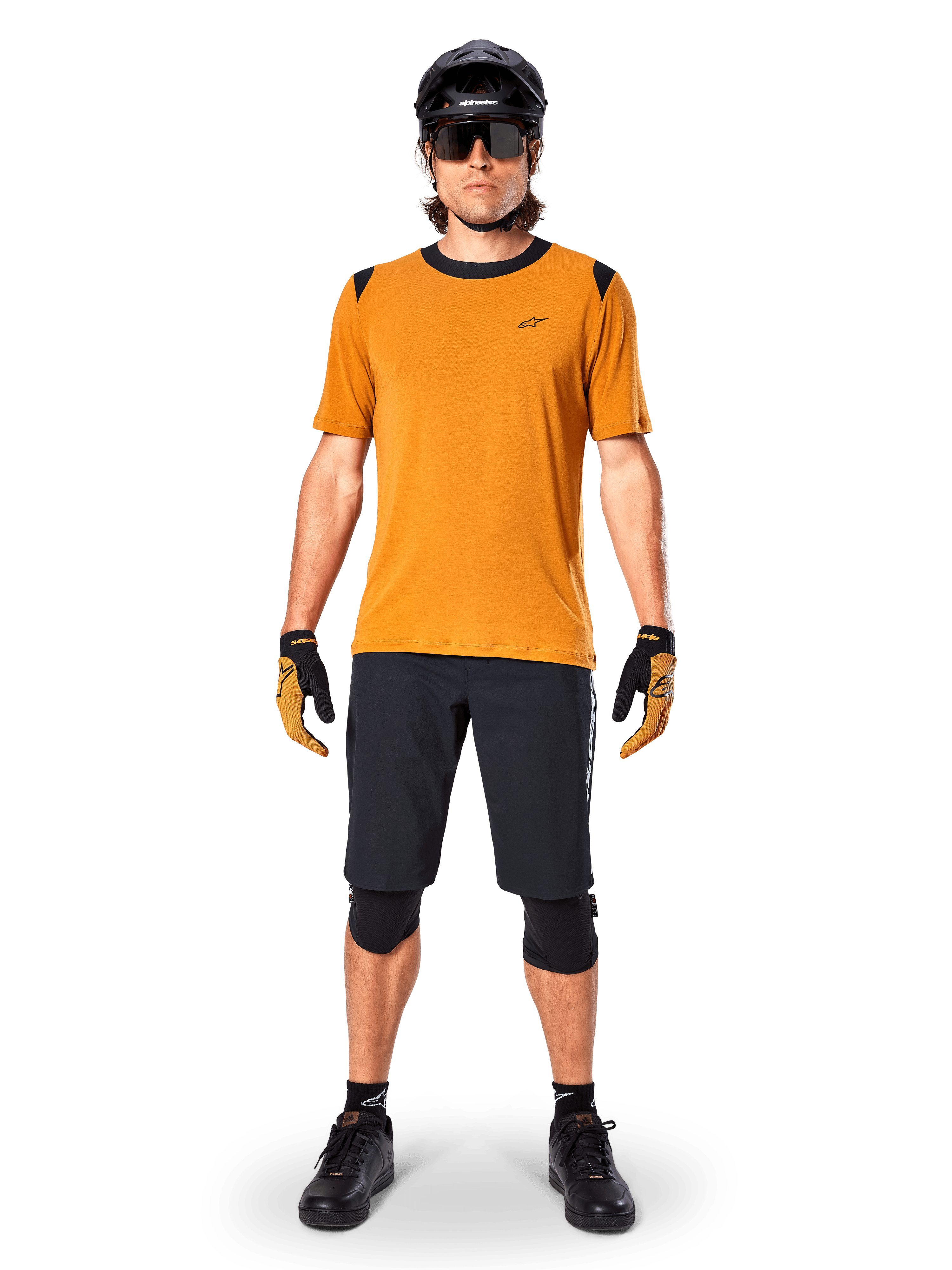 Alpinestars A-Dura Dri Wool Short Sleeve Jersey in Dark Gold, mountain bike jersey worn with black shorts and protective gear, mustard yellow fabric with black collar and shoulder accents, performance cycling apparel for trail riding.