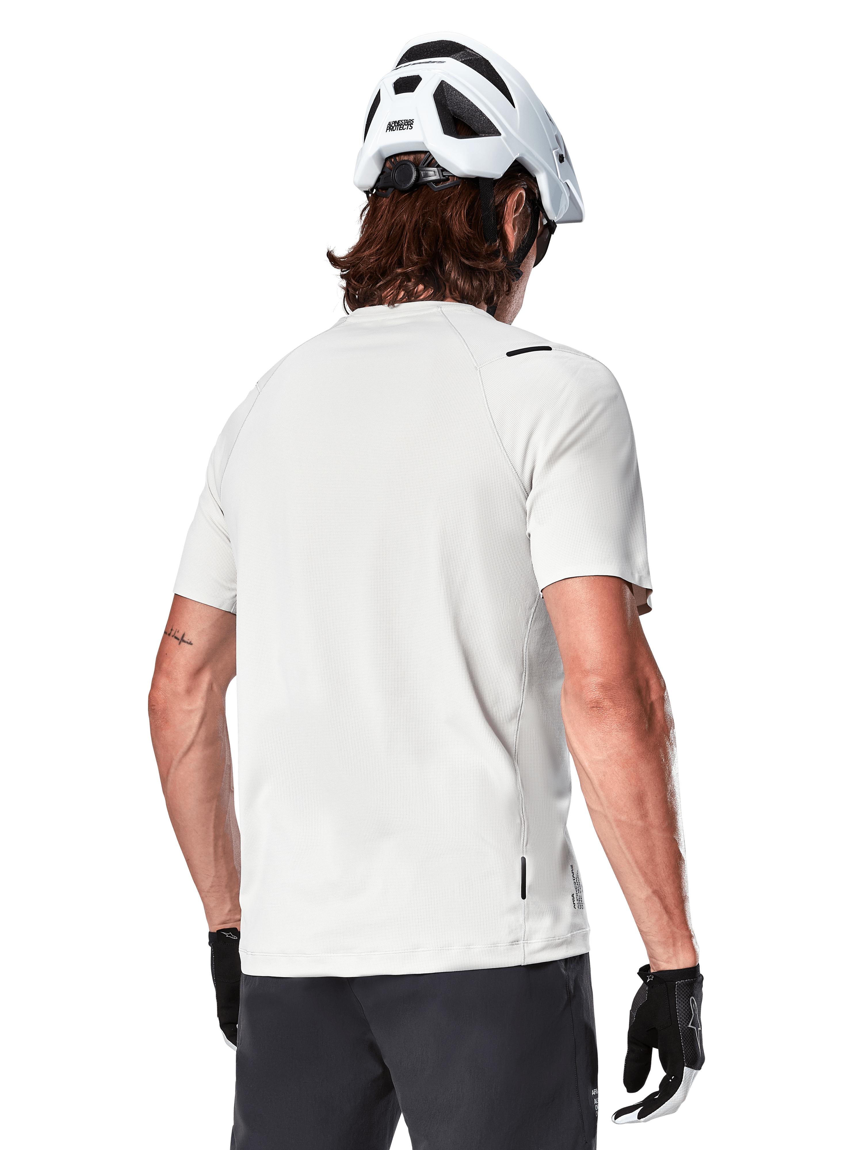 Alpinestars A-Aria Astar Jersey, Short Sleeve, White Dove, rear view of lightweight breathable mountain bike jersey, worn with a white helmet and black cycling gloves, featuring a dropped tail for extra coverage