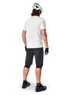 Cyclist wearing the Alpinestars A-Aria Astar Short Sleeve Jersey in White Dove, rear view, paired with black MTB shorts, knee guards, and a white helmet, lightweight and breathable gear for off-road mountain biking
