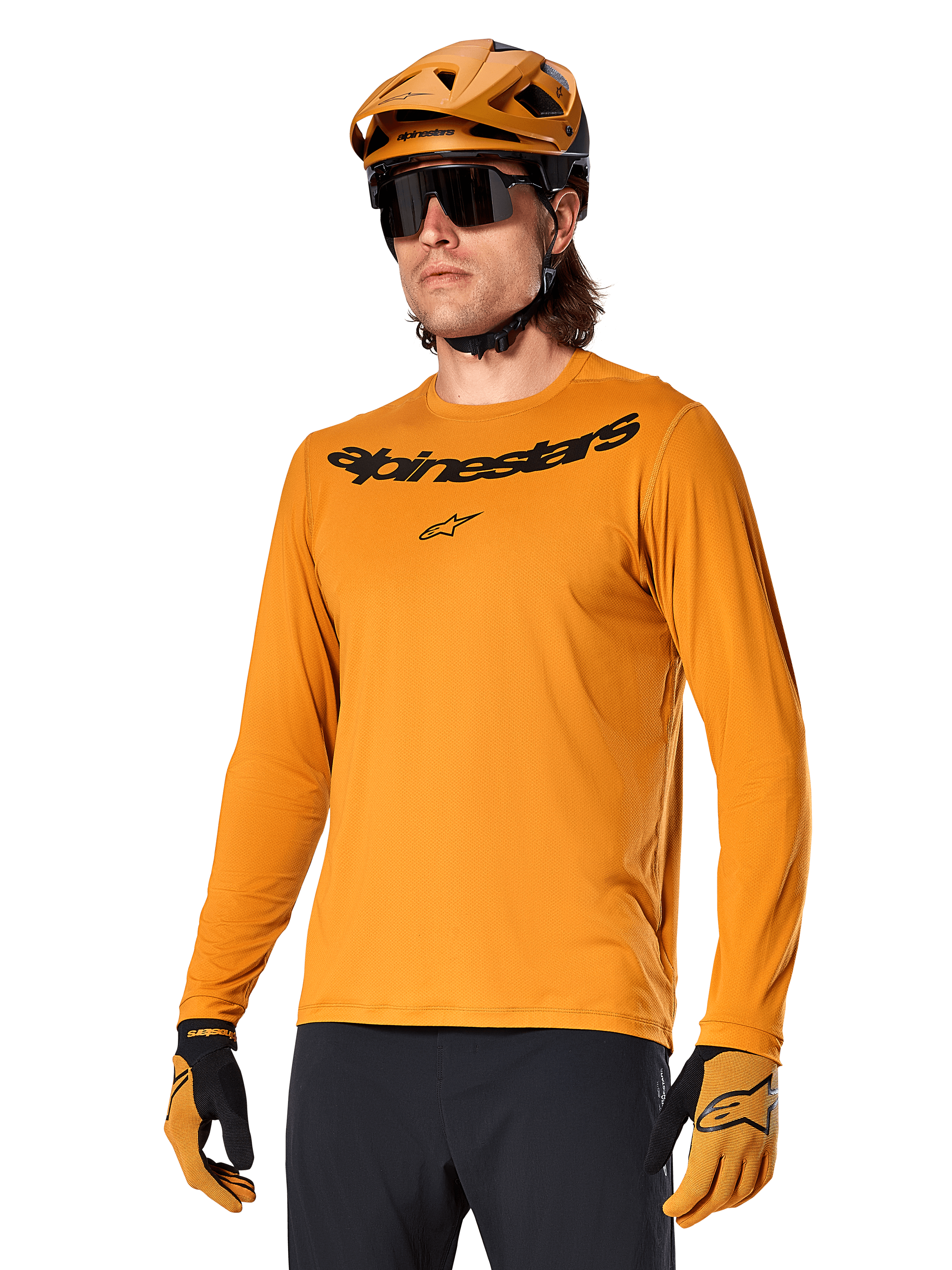 Maillot à manches longues Alpinestars A-Dura Rocker, maillot de VTT, Or foncé, personne portant le maillot avec un casque et des gants assortis, look sportif coordonné avec le logo Alpinestars sur la poitrine