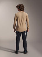 Maillot à manches longues Alpinestars A-Dura Astar, Brun clair, vue de dos montrant le pan arrière plus long, porté avec un pantalon noir arborant le logo Alpinestars, équipement de VTT haute performance