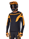 Alpinestars A-Supra Race Jersey - Long Sleeve, MTB Cycling Jersey, Black and Orange, worn with matching helmet and gloves, featuring Alpinestars branding on chest and stylized accents on sleeves, performance fit for off-road racing