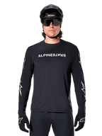 Alpinestars A-Dura Switch Long Sleeve Jersey, Black MTB jersey, white Alpinestars wordmark on chest and star graphics on the sleeves, worn with black mountain bike helmet and performance sunglasses, technical trail riding apparel