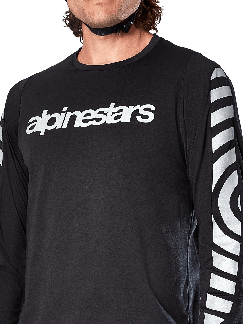 Maillot à manches longues Alpinestars A-Dura Dri Oscar, noir réfléchissant, vue rapprochée montrant le logo Alpinestars blanc sur la poitrine et les graphiques circulaires réfléchissants sur les manches, vêtement technique de cyclisme pour le VTT
