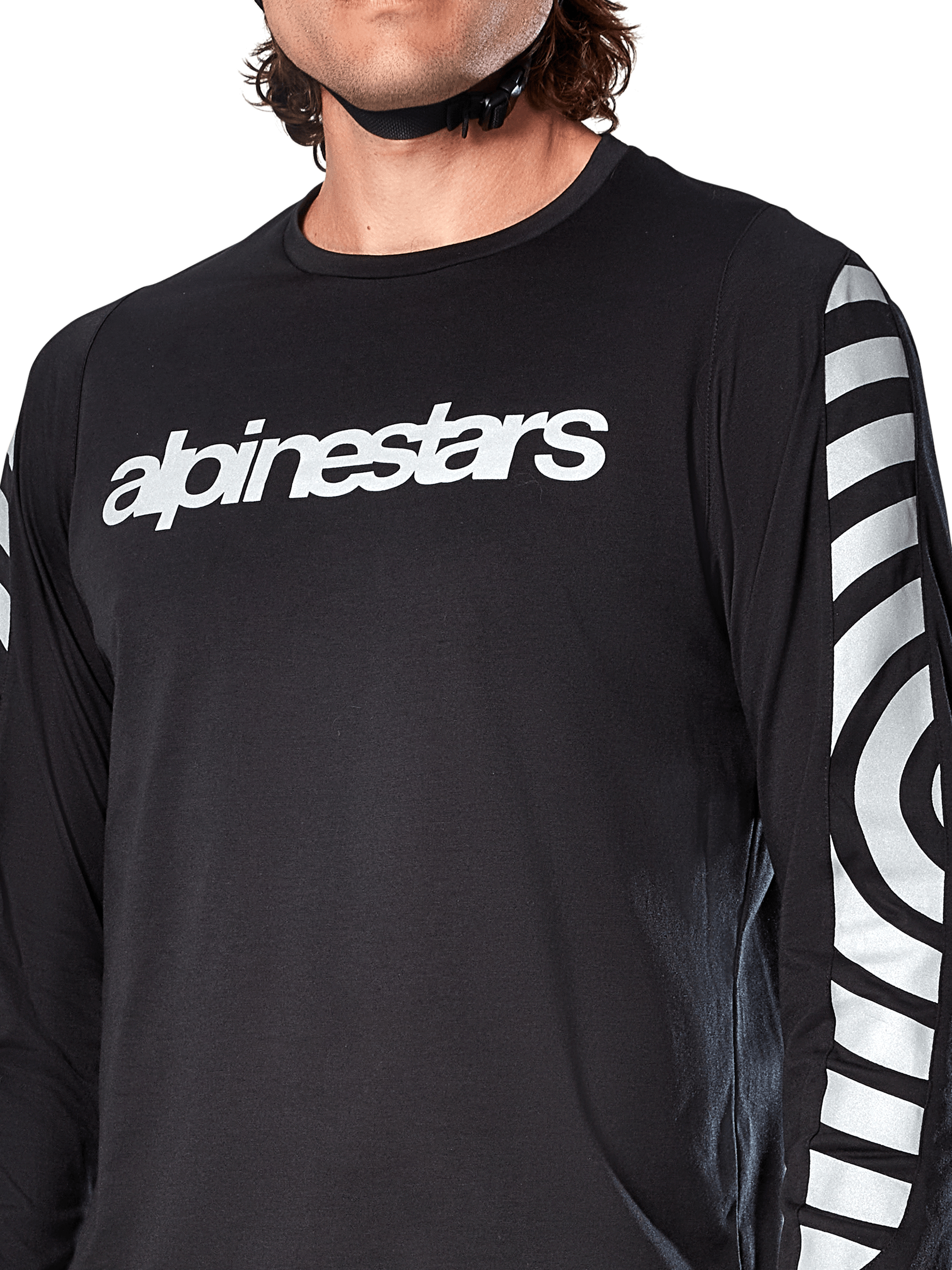 Maillot à manches longues Alpinestars A-Dura Dri Oscar, noir réfléchissant, vue rapprochée montrant le logo Alpinestars blanc sur la poitrine et les graphiques circulaires réfléchissants sur les manches, vêtement technique de cyclisme pour le VTT