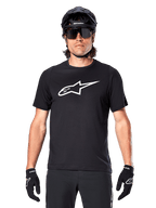 Alpinestars A-Dura Dri Oscar Jersey - Short Sleeve, Black Reflective, worn with black MTB helmet, sunglasses, and gloves, featuring a prominent white logo on the chest, performance gear for mountain biking