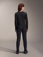 Maillot thermique Stella A-Dura Alpinestars pour femme, vue arrière, noir, maillot de cyclisme à manches longues avec polaire isolante, porté avec un pantalon et des chaussures noirs assortis, doté d'un petit marquage A-Dura en bas du dos et d'accents réfléchissants sur les épaules, conçu pour la pratique du VTT féminin.