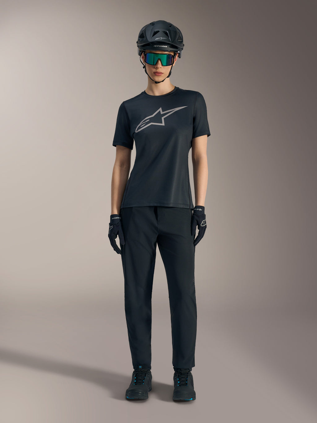 Maillot femme Stella A-Dura Ride noir à manches courtes, logo argenté, pantalon de VTT et casque tout-terrain.