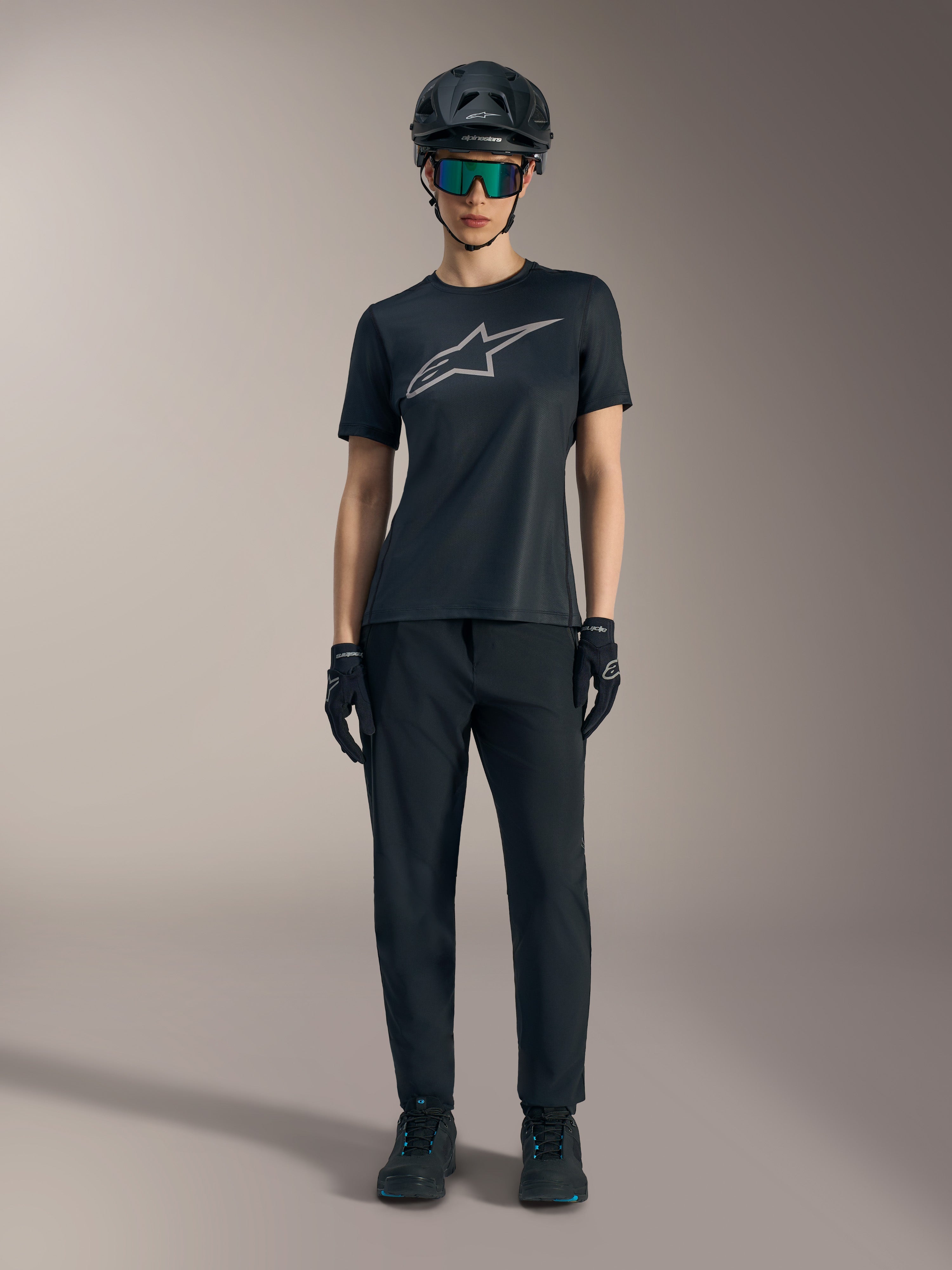 Maillot femme Stella A-Dura Ride noir à manches courtes, logo argenté, pantalon de VTT et casque tout-terrain.