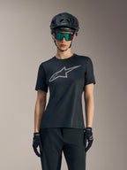 Maillot Stella A-Dura Ride noir pour femme, logo gris sur la poitrine, porté avec casque VTT et lunettes.