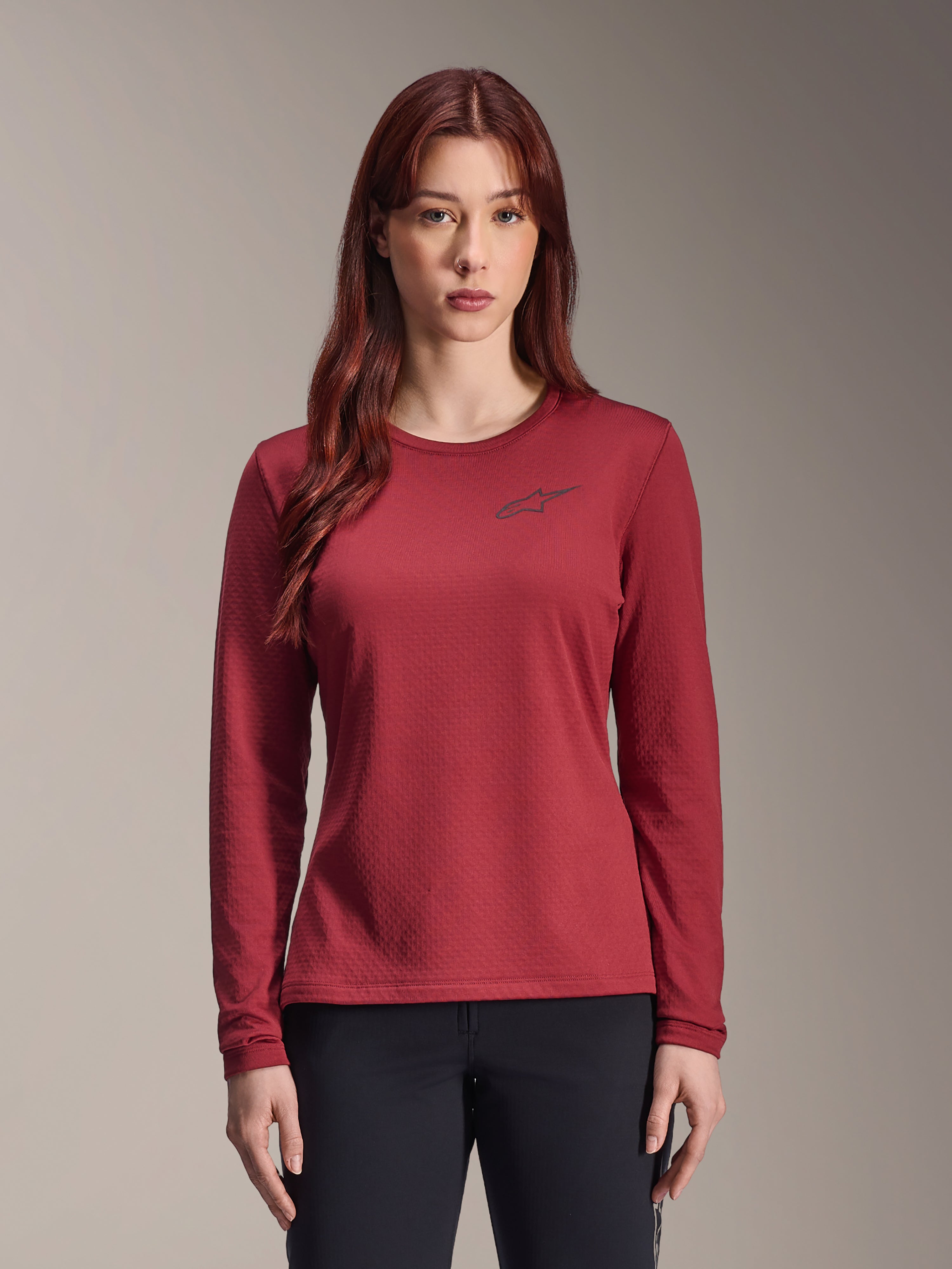 Alpinestars Stella A-Dura Thermal Jersey, maillot de VTT à manches longues pour femme, bordeaux, tissu thermique texturé, col rond avec petit logo Alpinestars noir sur la poitrine, porté par un mannequin