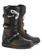 Bottes Alpinestars Tech-T, bottes de moto de trial, cuir huilé brun avec accents noirs, dotées de protège-tibias ergonomiques avec logo Alpinestars blanc, système de fermeture à triple boucle et semelle noire avec liseré rouge, chaussures tout-terrain robustes