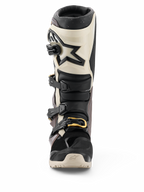 Bottes Alpinestars 2026 Tech 7 Enduro Drystar®, noir, gris foncé et or, bottes de moto tout-terrain imperméables, vue de face présentant un système de fermeture à boucles multiples avec des accents dorés, protection du tibia en TPU et design avec logo en étoile.