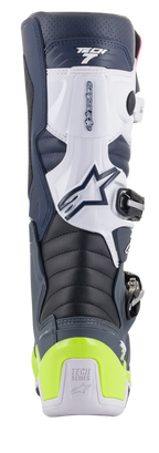 Bottes Alpinestars Tech 7, bottes de motocross, vue arrière montrant le coloris bleu foncé, blanc et gris foncé avec protection de talon jaune fluo, comprenant des zones de flexion en accordéon et le marquage Tech Series