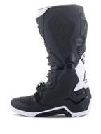 Bottes Alpinestars Tech 7 Enduro Drystar®, bottes de moto enduro, noir et blanc, vue du côté médial avec panneaux d'adhérence à texture en nid d'abeille, construction en TPU et accents blancs sur le talon et le haut du mollet, chaussures tout-terrain professionnelles