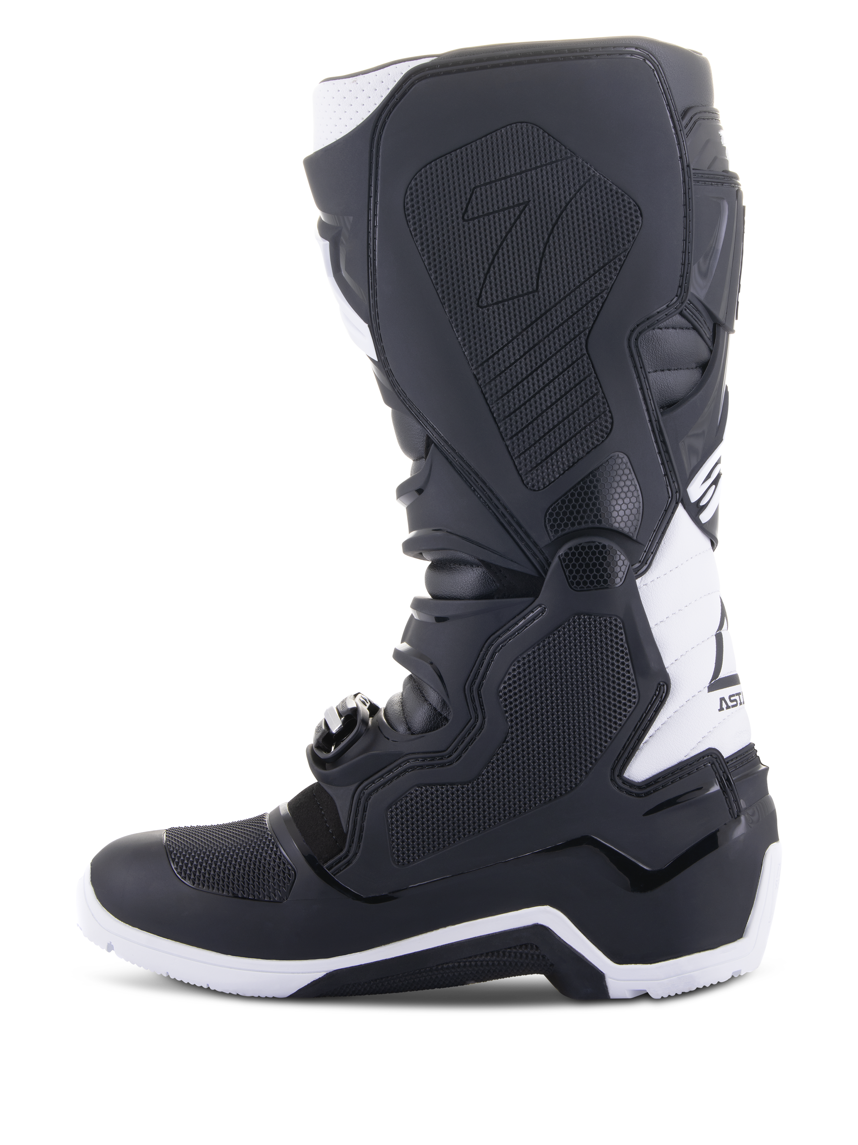 Bottes Alpinestars Tech 7 Enduro Drystar®, bottes de moto enduro, noir et blanc, vue du côté médial avec panneaux d'adhérence à texture en nid d'abeille, construction en TPU et accents blancs sur le talon et le haut du mollet, chaussures tout-terrain professionnelles