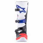 Bottes Alpinestars Tech 3, bottes de motocross, blanc, rouge vif et bleu foncé, vue de face montrant la plaque protège-tibia en TPU avec logo bleu, le système de fermeture à triple boucle et la section des orteils renforcée en rouge