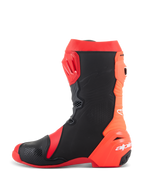 Bottes Alpinestars Supertech R, bottes de course moto professionnelles, rouge vif et rouge fluo avec panneaux noirs, vue de profil montrant la plaque tibiale en TPU, conception arrière flexible en accordéon et logo Alpinestars blanc sur le talon