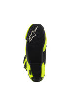 Bottes Alpinestars Supertech R, bottes de moto racing, jaune fluo et noir, vue de dessous montrant une semelle texturée noire avec logo Alpinestars blanc et des panneaux latéraux jaune vif