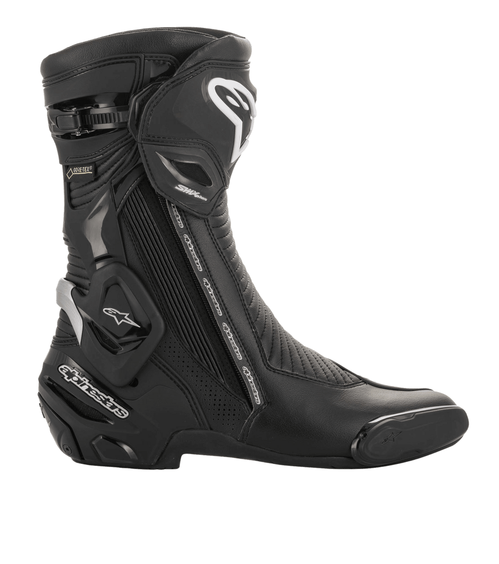 Botte Alpinestars SMX Plus V2 GORE-TEX, chaussure de sport moto, noir et argent, vue latérale avec logo Alpinestars blanc, plaque de protection du tibia et marquage GORE-TEX, conçue pour la course de haute performance et la conduite sur route