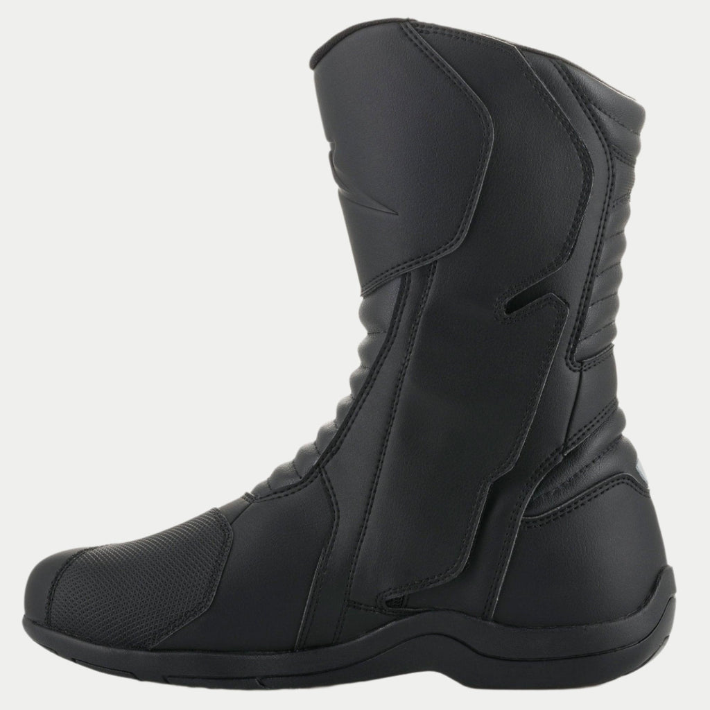 Bottes Alpinestars Origin Drystar®, bottes de moto touring noires, vue de profil du côté médial montrant le rabat du système d'ouverture, tige en microfibre avec zones de flexion en accordéon à l'avant et à l'arrière, conception imperméable durable pour la route et l'aventure