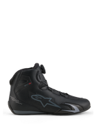 Chaussures Alpinestars Celer, chaussures de moto, noir et gris foncé, vue de profil montrant la molette du système de fermeture Rotor sur la languette, tige en microfibre technique avec logo Alpinestars gris, profil sport et course épuré