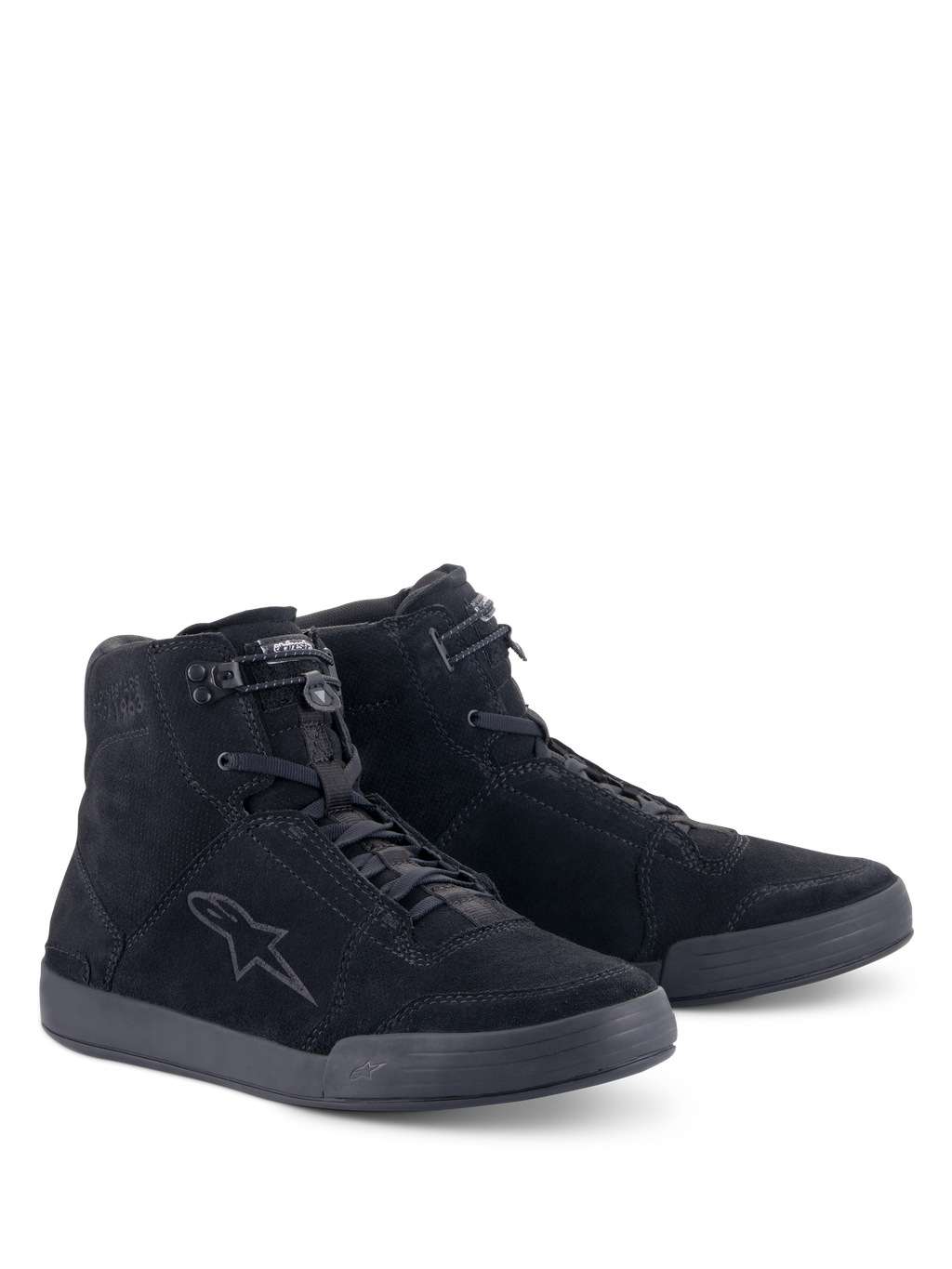 Chaussures Alpinestars Chrome, chaussures de moto urbaines, noir intégral, construction montante en daim fendu, avec un logo étoilé ton sur ton sur le côté, fermeture à lacets à l'avant avec élastique sur le dessus et semelle plate en caoutchouc pour un look urbain décontracté.