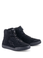 Chaussures Alpinestars Chrome, chaussures de moto urbaines, noir intégral, construction montante en daim fendu, avec un logo étoilé ton sur ton sur le côté, fermeture à lacets à l'avant avec élastique sur le dessus et semelle plate en caoutchouc pour un look urbain décontracté.