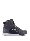 Chaussures Alpinestars Chrome Drystar, baskets de moto urbaines en noir, gris foncé et jaune fluo, avec empiècements en cuir et daim de qualité supérieure, semelle blanche, lacets jaune fluo et logo étoile emblématique.