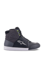 Chaussures Alpinestars Chrome Drystar, baskets de moto urbaines en noir, gris foncé et jaune fluo, avec empiècements en cuir et daim de qualité supérieure, semelle blanche, lacets jaune fluo et logo étoile emblématique.