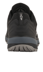 Chaussures Alpinestars Meta Trail, chaussures de course performantes, noir et gris foncé, vue arrière montrant la languette au talon avec logo Astar blanc, semelle intermédiaire gris foncé et semelle extérieure texturée, chaussures décontractées inspirées du sport automobile pour le paddock