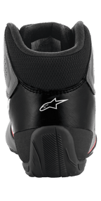Chaussures Alpinestars Tech-1 K Start V2, chaussures de karting, Noir Asphalte Orange Fluo, vue arrière montrant le logo Alpinestars blanc, col en mesh au niveau du tendon d'Achille et contrefort de talon en caoutchouc renforcé pour la stabilité.