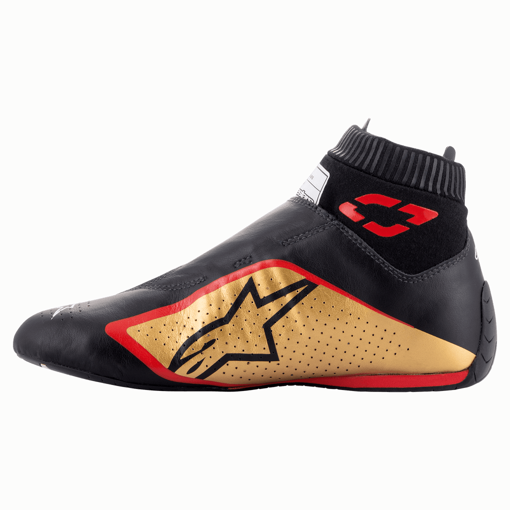 Alpinestars Supermono V2 Shoes FIA, Auto Racing Shoes, Black Gold and Red, side profile view featuring a sleek one-piece leather construction, gold side panel with black star logo, red accents, and a ribbed elastic collar.