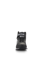Chaussures Alpinestars Radar, chaussures de course automobile pour équipe de stand, noir et blanc, vue de face montrant des lacets noirs et une sangle de cheville à scratch avec logo blanc, tige en cuir perforé avec bout renforcé, chaussures professionnelles pour équipe de stand