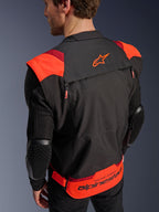Veste Alpinestars T-Stunt Air, noir, rouge fluo et rouge foncé, vue arrière sur un mannequin, montrant les manches en mesh avec protections de coudes texturées en nid d'abeille, logo étoile Alpinestars sur le haut du dos et marquage « RACING AHEAD » en bas du dos, design modulaire à coupe sportive pour la conduite moto.