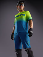 Short Alpinestars A-Dura Ride bleu, maillot dégradé vert lime et bleu et équipement de protection VTT