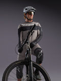 Maillot manches longues Alpinestars A-Dura Race gris, accents noirs, porté par un pilote de VTT équipé.